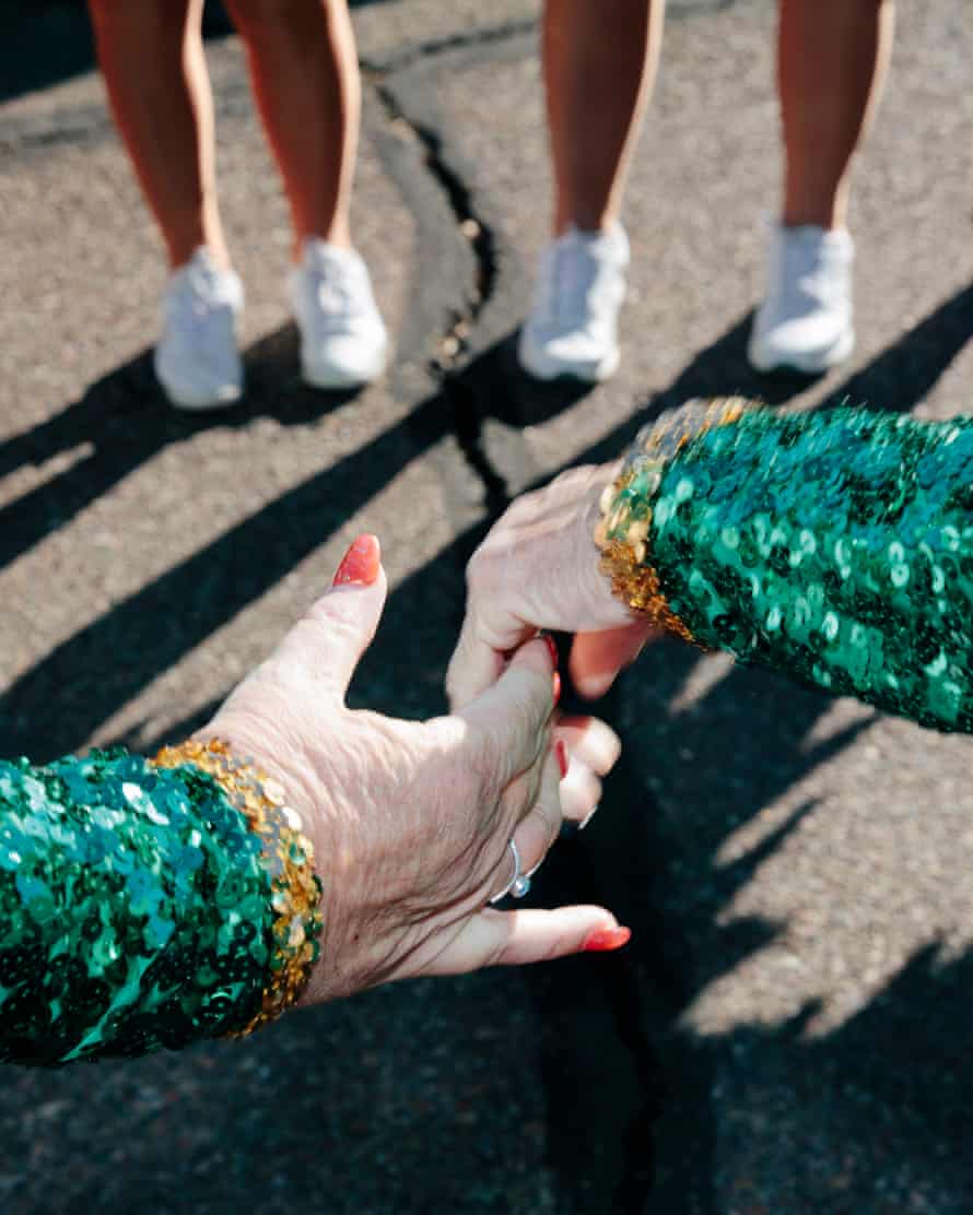 Members of the Sun City Poms cheerleading group hold hands before a performance