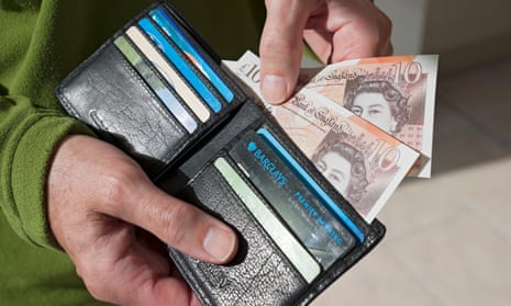 Man taking new £10 notes from wallet