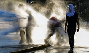 Demonstrators clash with riot police during an anti-government protest in Santiago, Chile
