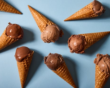 Multiple chocolate ice cream cones arranged on a light blue surface