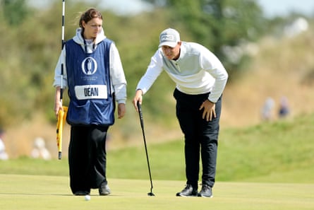 Joe Dean of England lines up a putt with his fiancee and caddie Emily