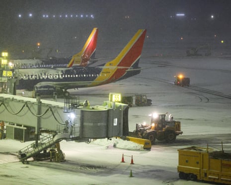 A snow removal machine working on the tarmac of LaGuardia airport in snowy conditions