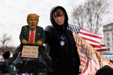 Saint Paul, MinnesotaA woman holds a sign featuring US President Donald Trump as a large crowd of demonstrators gather outside the Minnesota State Capitol