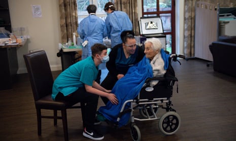 Care home resident Vera Levick, 106, is comforted by staff before receiving an injection of the coronavirus vaccine at Andrew Cohen House in Birmingham.