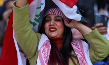 Om Fahed appears to be dancing holding a flag over her head