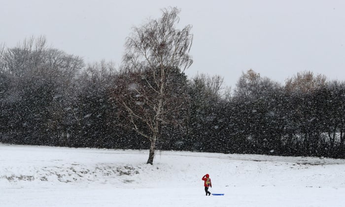 A boy heads out to use his sledge in Danbury, Essex