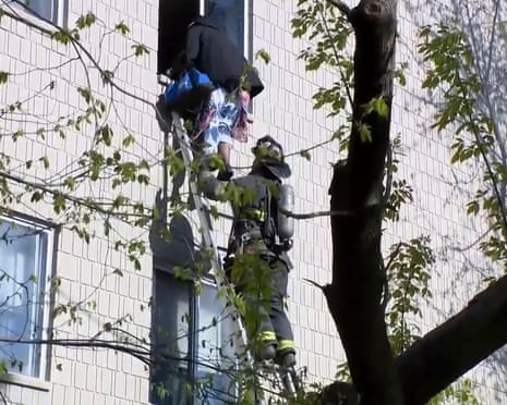 US Apartment Building Fire<br>In this image made from video, a firefighter on ladder helps a person out of the window at the site of an apartment building fire in Milwaukee, Wisconsin, on May 11, 2025.(WISN via AP)