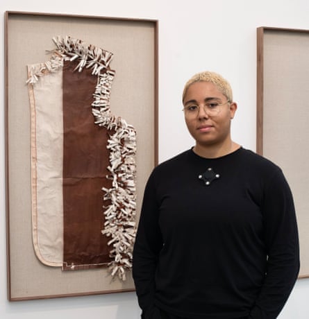 Tanoa Sasraku in front of their artwork.