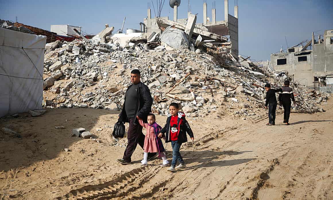Palestinians walk past the rubble of buildings destroyed in previous Israeli strikes in Khan Younis in the southern Gaza Strip.