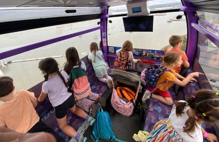 Children look out the windows of a bus.