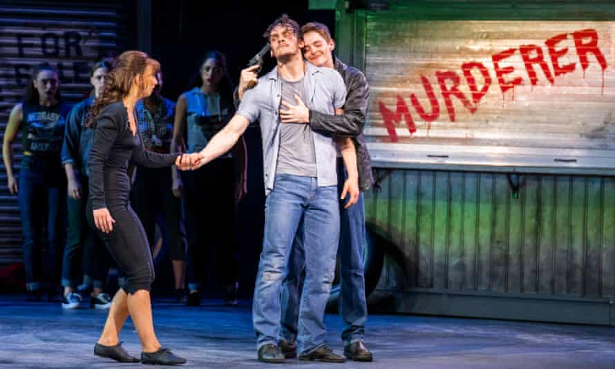 Paris Fitzpatrick (Angelo) holds a gun to the head of Will Bozier (Luca) while Zizi Strallen (Lana) looks on, aghast