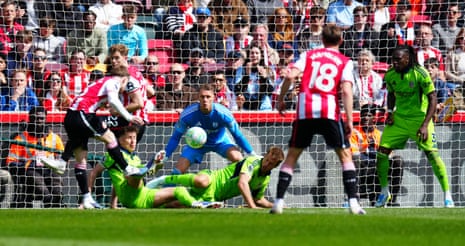 Tom Cairney and Joachim Andersen of Fulham do enough to force Keane Lewis-Potter of Brentford to shoot over the bar.