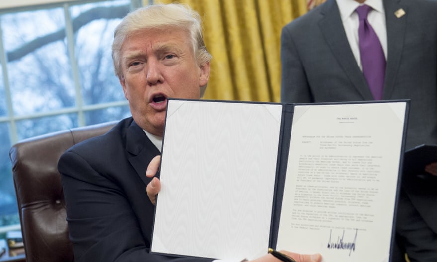 President Donald Trump with an executive order withdrawing the US from the Trans-Pacific Partnership.
