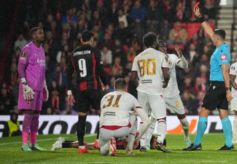 Referee shows AC Milan goalkeeper Mike Maignan a red card during a rainy match