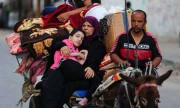 A Palestinian family flees Rafah, travelling on a donkey