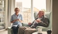 Senior man and female carer enjoying coffee at homeIndoor shot of smiling senior man and female carer enjoying coffee in living room