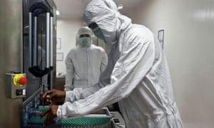 An employee in personal protective equipment removes vials of AstraZeneca’s Covidshield coronavirus vaccine from a visual inspection machine inside a lab at Serum Institute of India, in Pune .