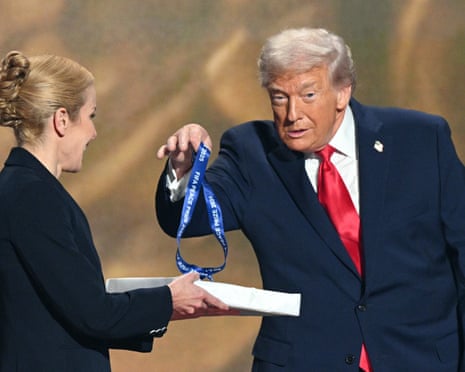 Donald Trump grabs his medal.