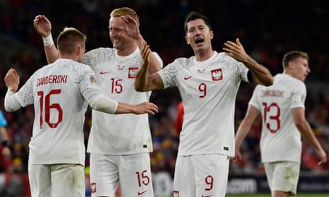 Poland's Karol Swiderski celebrates scoring their first goal with Kamil Glik and Robert Lewandowski.