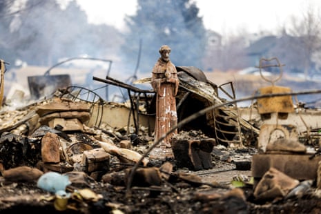A statue stands amidst the remains of homes destroyed by the Marshall Fire in Louisville, Colorado, on Friday.