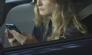 Woman checks phone in a car