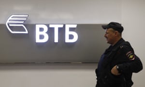 A police officer stands guard near a sign with the logo of the Russian lender VTB in Moscow 3500.jpg?w=300&q=55&auto=format&usm=12&f