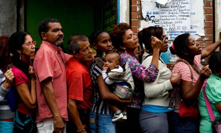 People queue to buy food and basic household items in the Petare neighbourhood of Caracas.