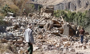 People walk on the rubble of a house destroyed by an airstrike in Sana’a in Yemen