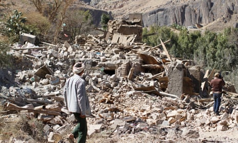 People walk on the rubble of a house destroyed by an airstrike in Sana’a in Yemen