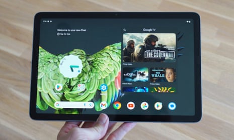 Google Pixel Tablet held in a hand over a table.