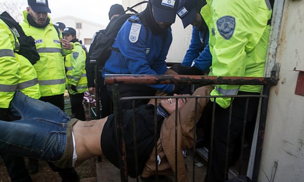 A settler is removed by police from one of the houses in Amona in February.