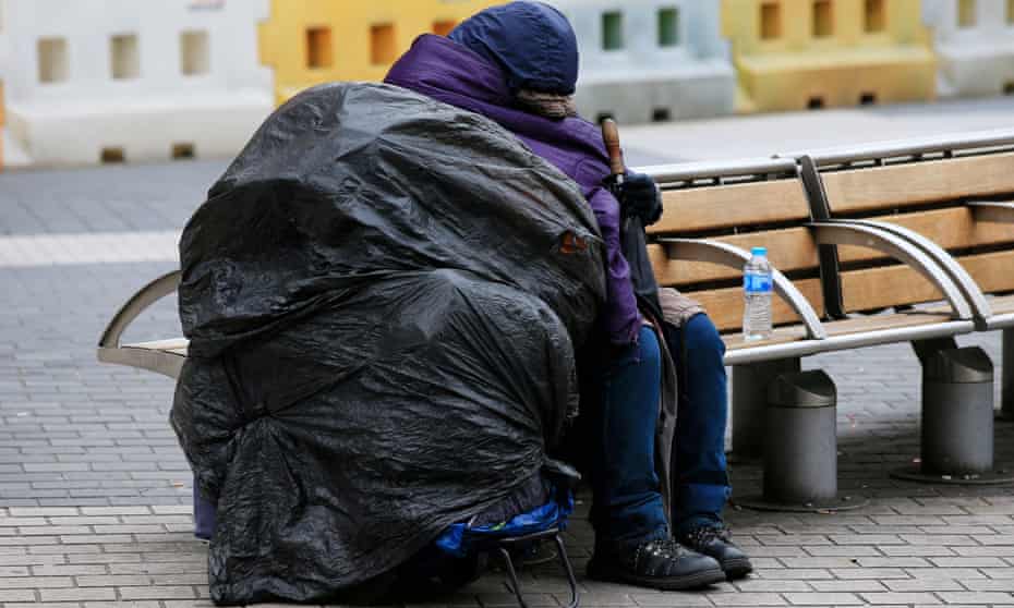Homeless person resting on a bench