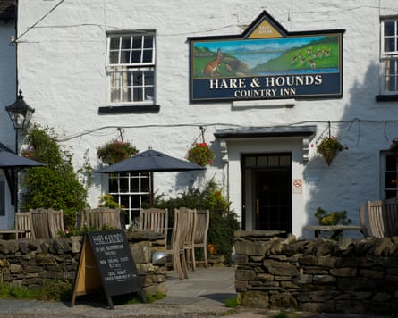 Outside the Hare and Hounds pub with a lovely sign of the pub showing a picture of a rabbit in a field with lots of bunnies hopping around