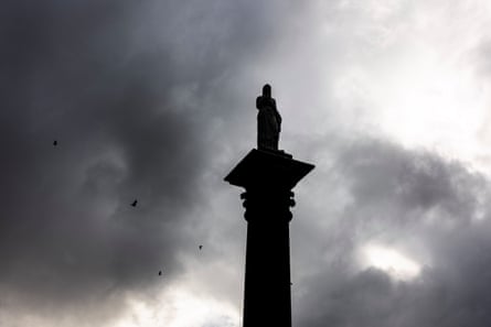 A statue sits high in the sky on top of a huge sandstone pedestal in Centennial Park