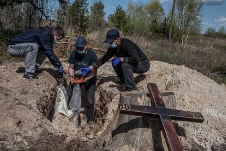 Volunteers pulling body from grave.