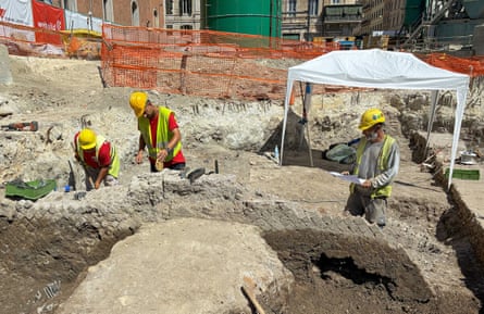 Archaeologists at work beside a Roman brick wall