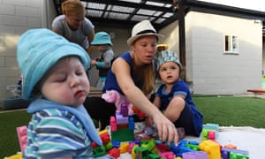 Samantha Rowney sits with childcare attendees Anna Ganlath (left) and Xavier Kerrigan (right) during a visit by the Australian Prime Minister Malcolm Turnbull (not pictured) to the The Playground Early Learning Centre in Red Hill, Canberra,
