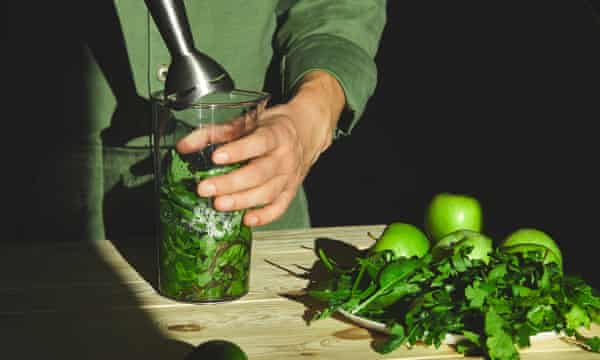 緑の野菜と緑のリンゴがスムージーにブレンドされています。