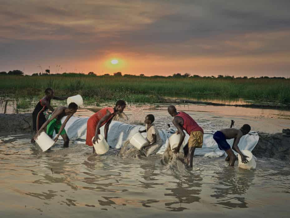 A family works together into the night to try to remove floodwater