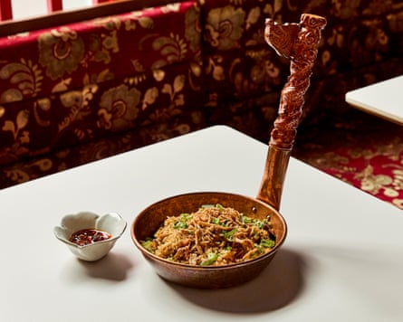 ข้าวผัดในชามที่มีด้ามจับแกะสลักยาวตั้งขึ้น