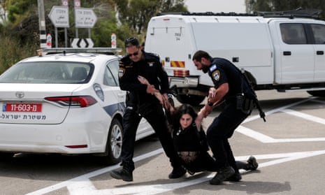 Israeli police detain a protester during a demonstration by Israeli and American Rabbis as they block a road while they gather to symbolically bring food to Gaza, near Erez crossing.