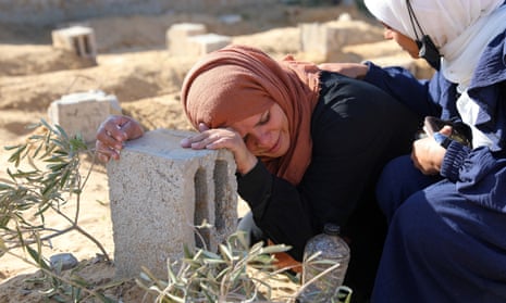 A Palestinian woman at the grave of her son, killed in an Israeli strike in Khan Younis