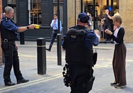 Police officers arrest a woman after four people were stabbed in Covent Garden.