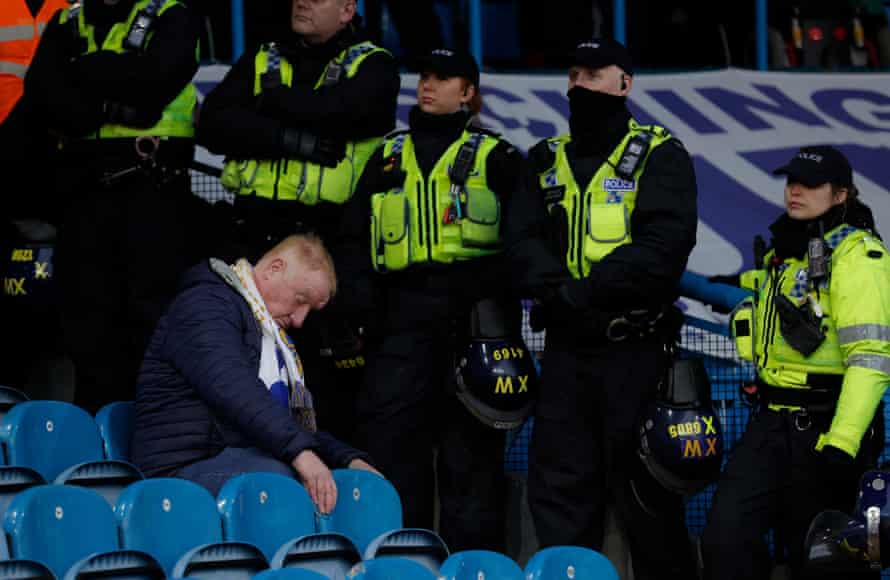 A Leeds fan flanked by police after the defeat.