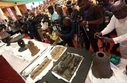 People photographing artefacts on a long table