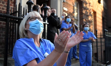 Hospital staff in London take part in the weekly ‘clap for carers’ tribute