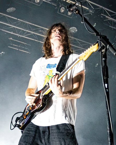 The musician Mk.gee onstage playing an electric guitar