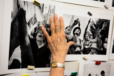 A hand covers photos pinned to a wall