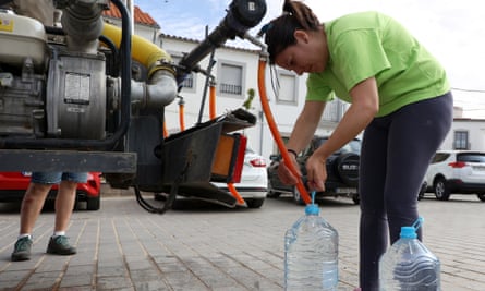 A woman fills bottles with drinking water from a truck in Alcaracejos, Spain, on 27 April after the local reservoir nearly dried out.