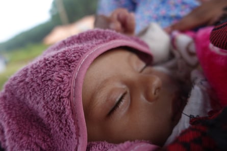 Closeup of a baby’s face, wrapped in a pink towel